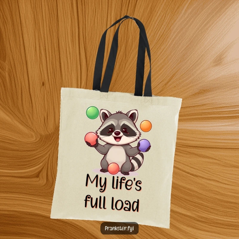 Funny Tote Bag depicting a happy raccoon juggling three colorful balls, adding a playful touch to everyday tasks.
